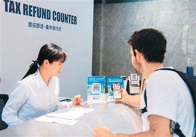 西班牙游客在上海新天地使用“支付宝碰一下”办理退税。徐紫澄 摄